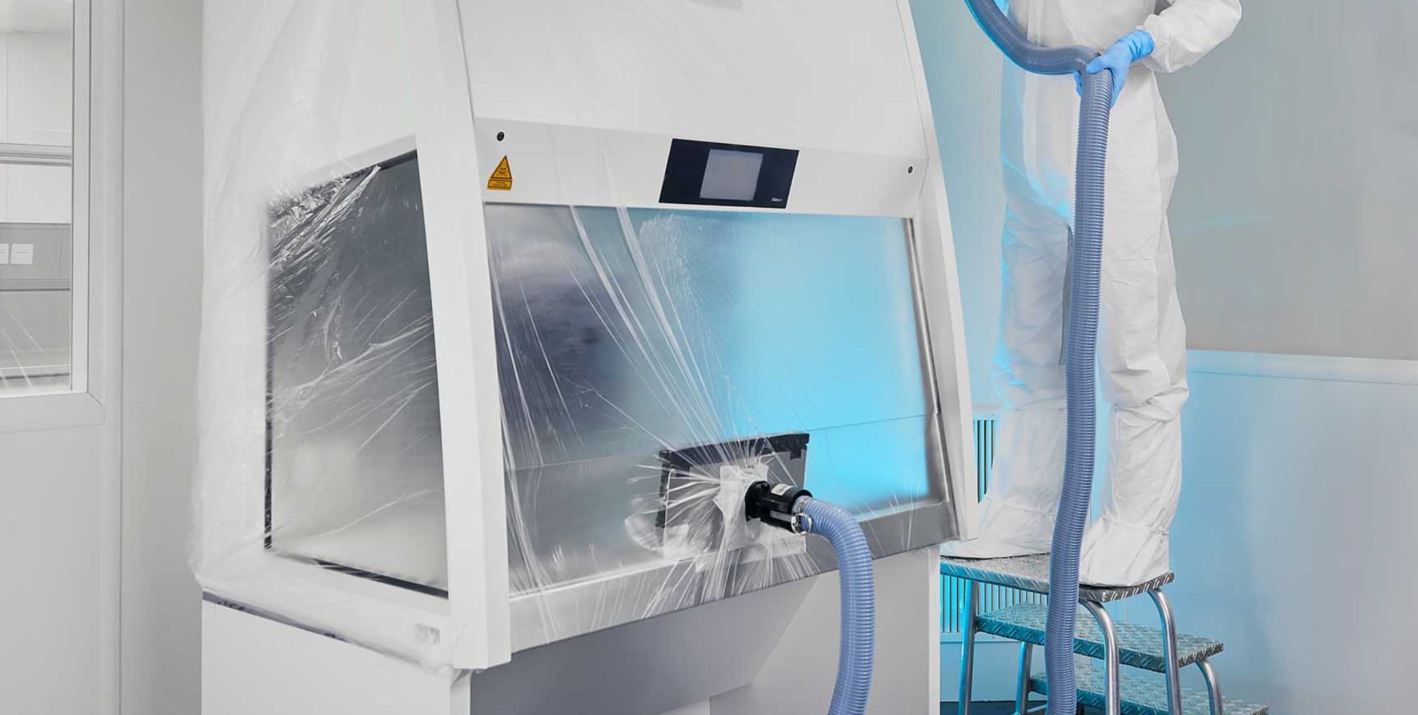 Technician at isolator in cleanroom – biosafety cabinet with HEPA filtration for microbial air sampling